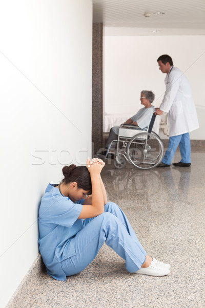 Nurse sitting on the ground in the hallway getting depressed Stock photo © wavebreak_media