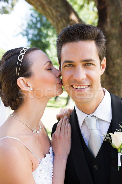 Beautiful bride kissing groom on cheek in garden Stock photo © wavebreak_media