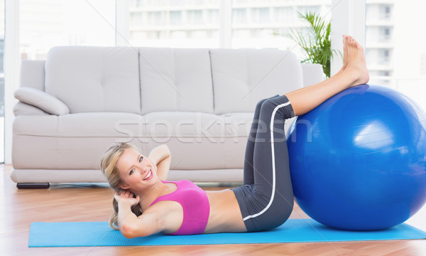Cheerful fit blonde doing sit ups with exercise ball Stock photo © wavebreak_media