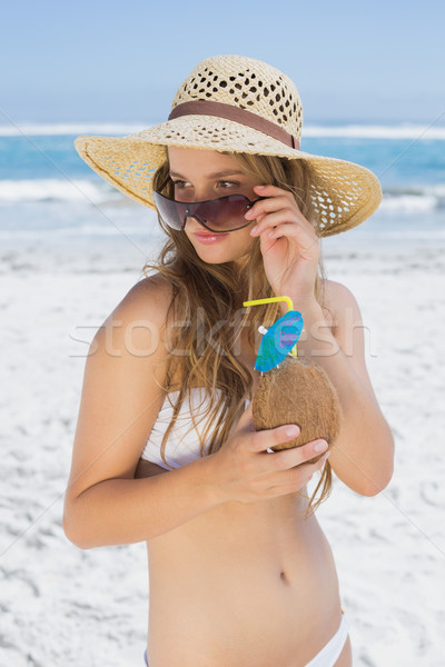 Pretty blonde in white bikini holding coconut drink on the beach Stock photo © wavebreak_media