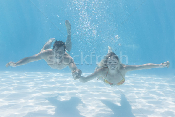 Drăguţ cuplu zâmbitor aparat foto sub apă piscină Imagine de stoc © wavebreak_media