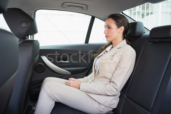 Unsmiling businesswoman sitting in the back seat Stock photo © wavebreak_media