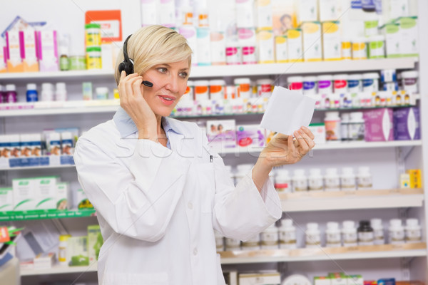 Farmacéutico auriculares lectura prescripción farmacia mujer Foto stock © wavebreak_media