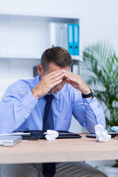 Businessman with severe headache sitting at office desk Stock photo © wavebreak_media