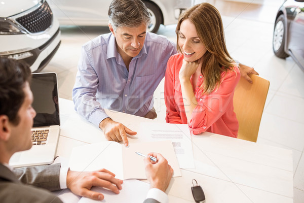 Stock photo: Smiling couple buying a new car