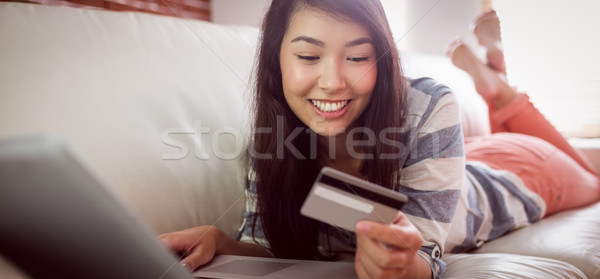 Souriant asian femme canapé comprimé magasin [[stock_photo]] © wavebreak_media