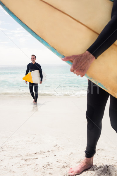 Hombre caminando tabla de surf playa océano Foto stock © wavebreak_media