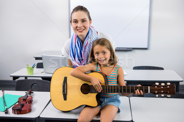 Teacher assisting girl to play guitar Stock photo © wavebreak_media