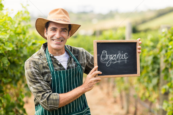 Portrait of smiling farmer holding an organic sign Stock photo © wavebreak_media