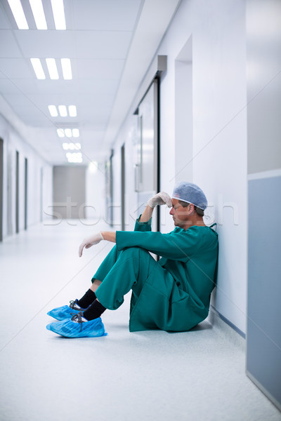 Tensed male surgeon sitting in corridor Stock photo © wavebreak_media
