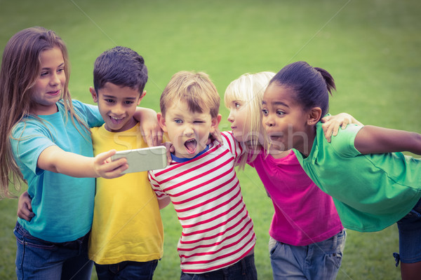 Smiling classmates posing funny and taking selfies  Stock photo © wavebreak_media