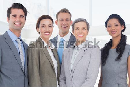 Stock photo: Smiling manager with folded arms in front of his team