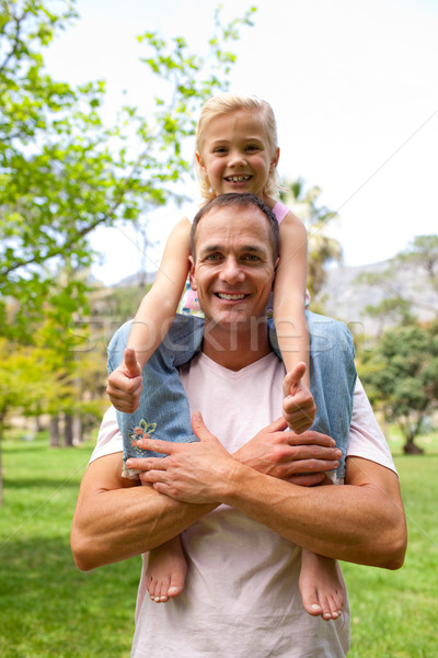 Stock photo: Happy father giving his daughter piggy-back ride 
