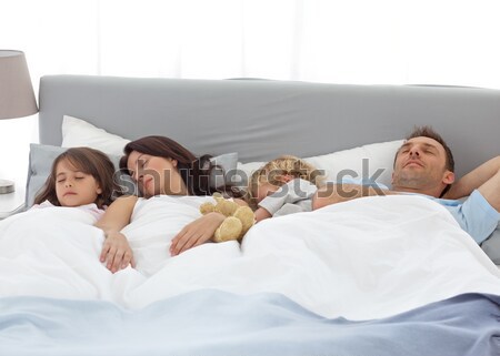 Cute family sleeping together in the parents's bed Stock photo © wavebreak_media