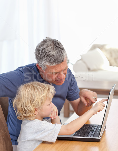 Stock photo: Lovely boy and his grandfather looking at their laptop