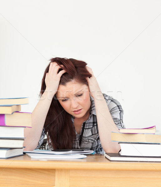 Attractive red-haired female being depressed while studying for an examination at her desk Stock photo © wavebreak_media