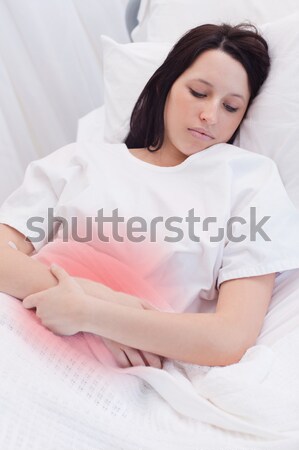 Close up of a Red-haired woman lying in bed turning off alarm clock in her bedroom Stock photo © wavebreak_media