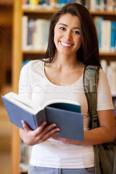 Portrait of a cute student holding a book in the library Stock photo © wavebreak_media