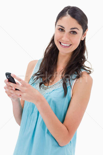 Portrait of a happy woman reading a text message against a white background Stock photo © wavebreak_media