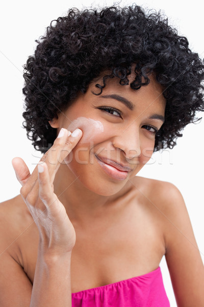 Smiling woman putting some cream on her face with her fingers Stock photo © wavebreak_media