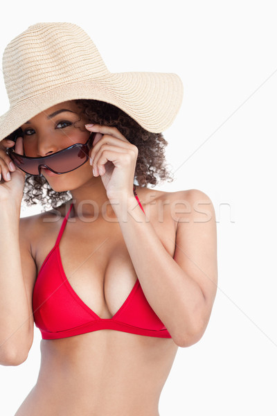 Young woman in beachwear putting on her sunglasses against a white background Stock photo © wavebreak_media
