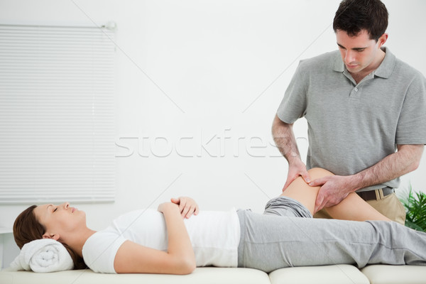 Physiotherapist massaging the leg of a woman while standing in a room Stock photo © wavebreak_media