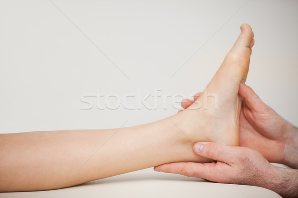 Chiropodist holding the foot of a patient in a medical room Stock photo © wavebreak_media