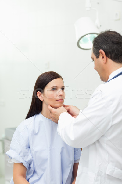 Doctor touching the neck of a patient in an examination room Stock photo © wavebreak_media