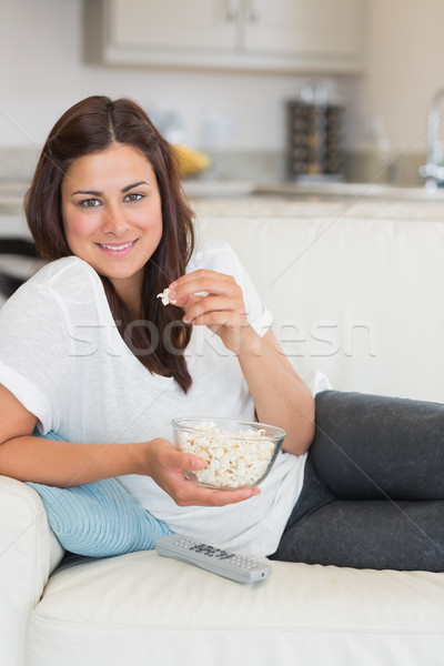 Brünette Essen Popcorn entspannenden Sofa Haus Stock foto © wavebreak_media