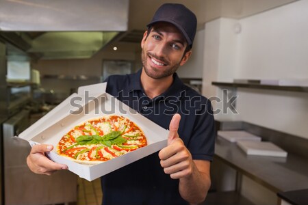Happy female chef with pizza  Stock photo © wavebreak_media