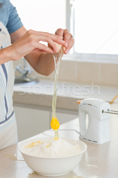 Mid section of woman cracking an egg in bowl at kitchen Stock photo © wavebreak_media