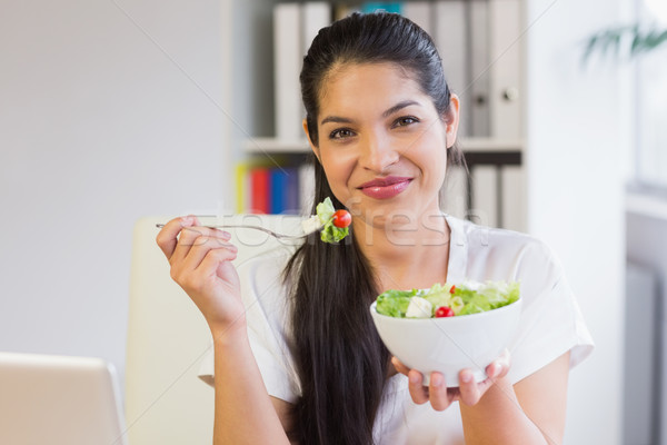 Mujer de negocios comer ensalada oficina retrato sonriendo Foto stock © wavebreak_media