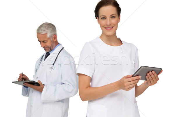 Stock photo: Male and female doctors using digital tablets