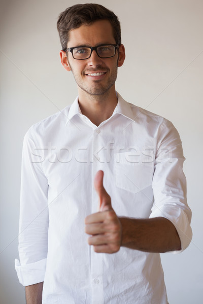 Casual businessman giving thumbs up to camera Stock photo © wavebreak_media