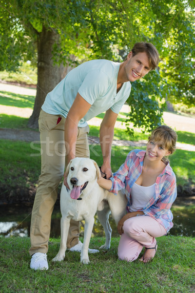 Happy couple with their labrador in the park smiling at camera Stock photo © wavebreak_media