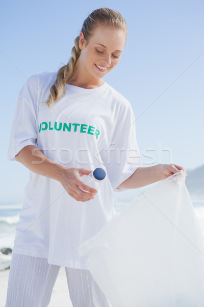Voluntar in sus Coşul de gunoi plajă Imagine de stoc © wavebreak_media