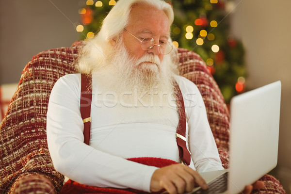 Stock photo: Father christmas typing on laptop