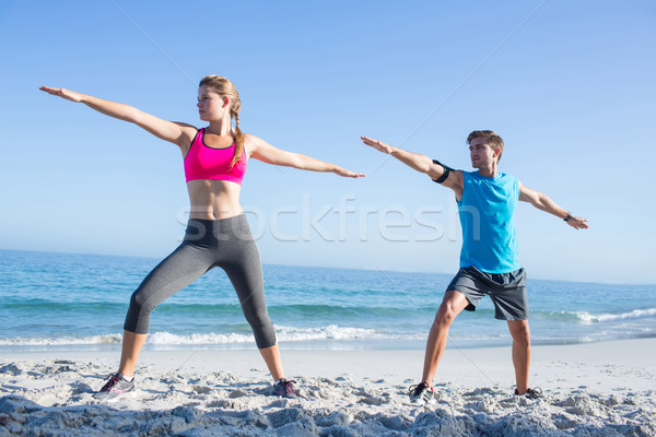 Happy couple doing yoga beside the water Stock photo © wavebreak_media