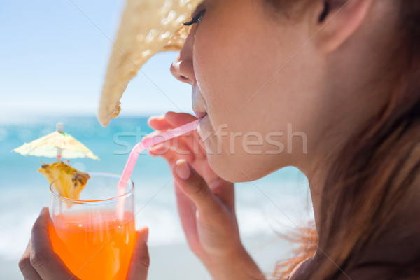 Bruneta palarie de paie potabilă cocktail plajă Imagine de stoc © wavebreak_media