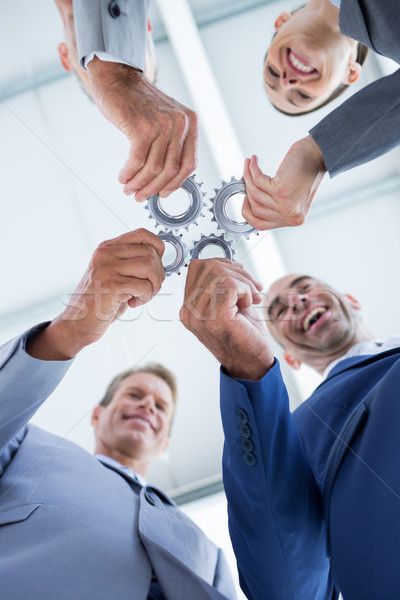 Business colleagues holding cog Stock photo © wavebreak_media
