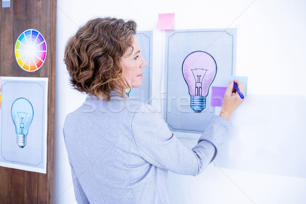 Stock photo: Wear view of creative businesswoman writing on post it 