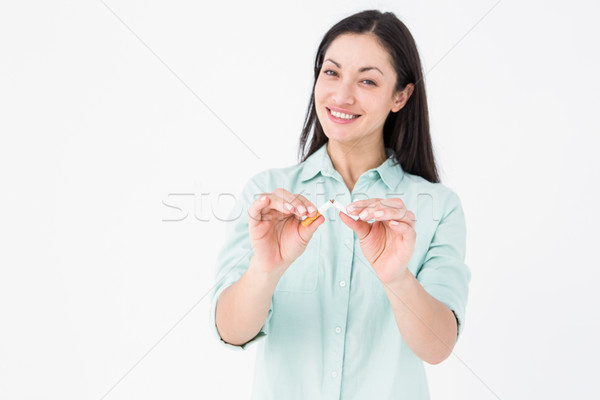 Smiling woman snapping cigarette in half Stock photo © wavebreak_media