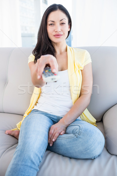 Joli brunette regarder caméra télécommande [[stock_photo]] © wavebreak_media