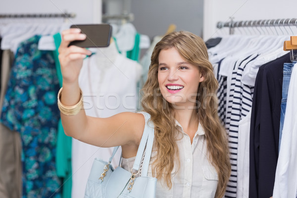 Bastante sonriendo mujer rubia toma ropa tienda Foto stock © wavebreak_media