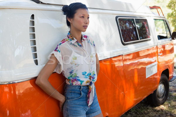 Stock photo: Woman leaning on camper van in the park