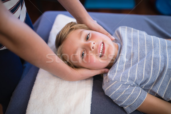 Stock photo: High angle portrait of smiling smiling boy receiving massage from female therapist