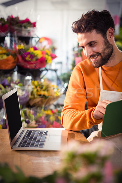 Male florist checking order in laptop Stock photo © wavebreak_media