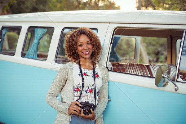 Woman leaning on campervan with camera Stock photo © wavebreak_media