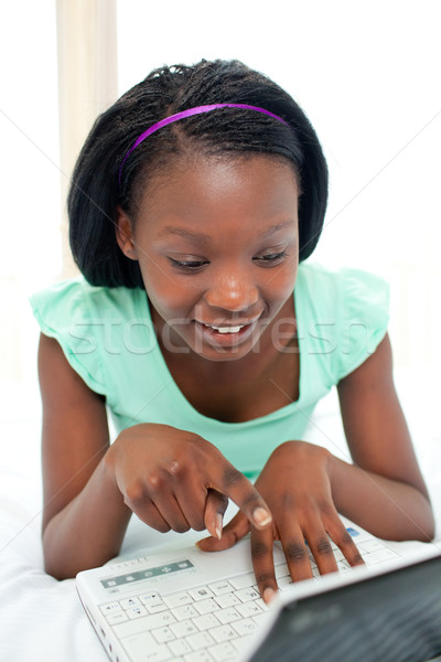 Beautiful woman using a laptop sitting on bed Stock photo © wavebreak_media