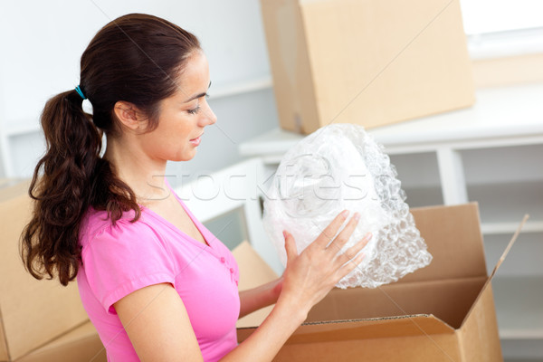 Young caucasian woman unpacking boxes with glasses in her new house Stock photo © wavebreak_media